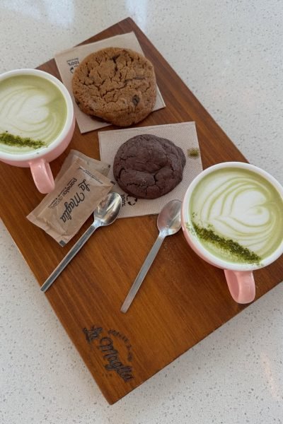 Varias latas de té matcha orgánico en colores vibrantes dispuestas en una caja.