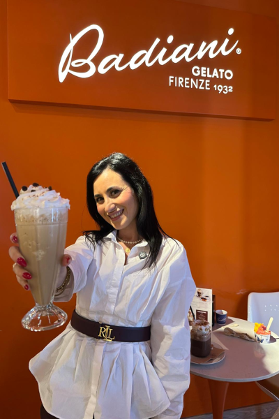 Laura Lobato mostrando un batido en Badiani Gelato, destacando su estilo foodie y lifestyle, en un entorno luminoso y colorido.