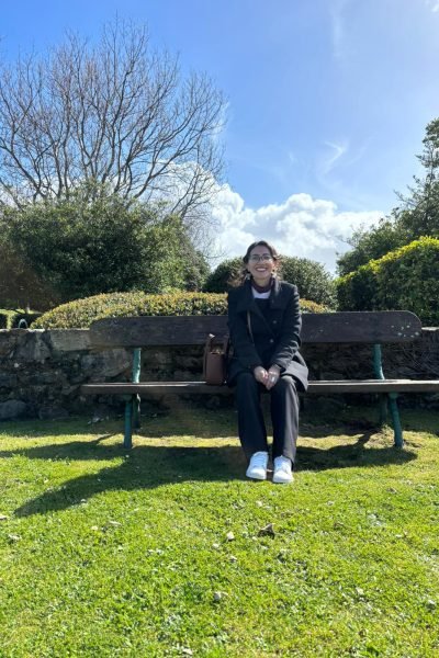 María del Carmen Ramírez, UGC creadora de contenido, sentada en un banco en un parque, disfrutando del aire libre.