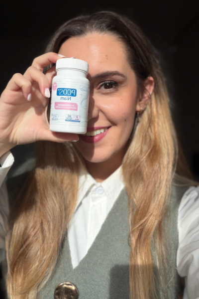 Nerea López mostrando el suplemento PCS Niám con sonrisa y luz natural, promoviendo bienestar y confianza en su uso.