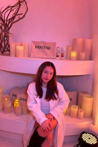 Noelia García sonriente sentada frente a decoración de velas, influencer y creadora de contenido promocionando productos.