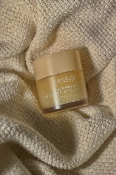 Envase del producto Laneige Lip Sleeping Mask con aroma a vainilla sobre una tela beige.