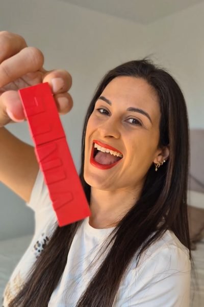 Sara Barrio mostrando el labial Maybelline SuperStay en tono rojo, destacando el maquillaje y la durabilidad del producto.