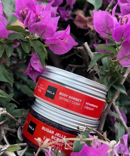 Sheila Vivas presenta los productos NALA: Body Sorbet y Sugar Jelly Scrub, rodeados de flores, demostrando cómo cuidar la piel de manera natural.