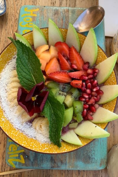 Bowl de frutas frescas con fresa, kiwi, granada y menta, servido en un tazón colorido, capturado por Cristina Jiménez UGC